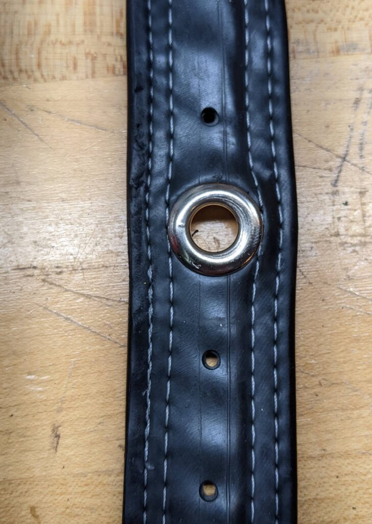 the original belt, now with a gleaming grommet installed that is a little too big